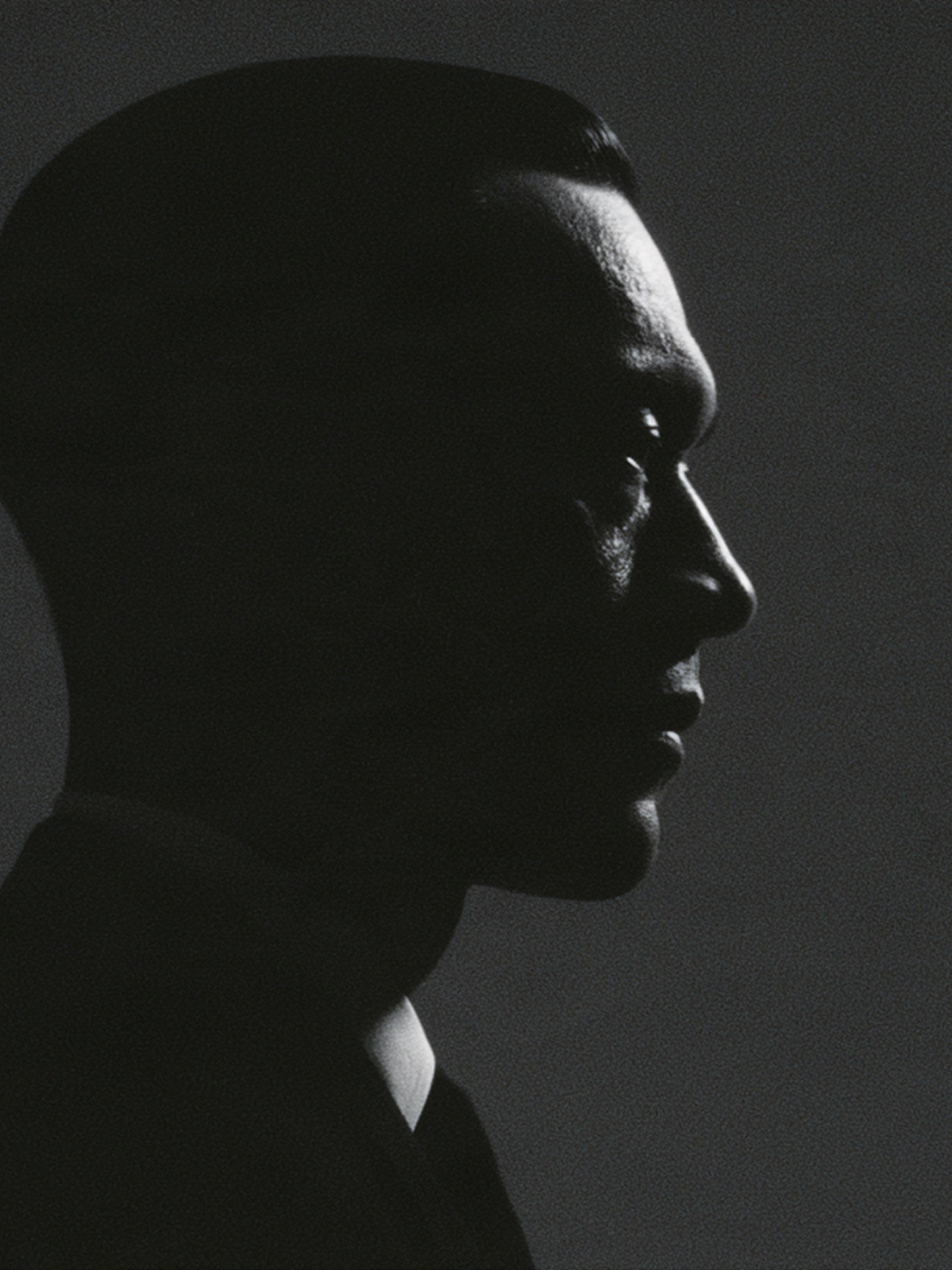 A figure in profile, lit from one side.